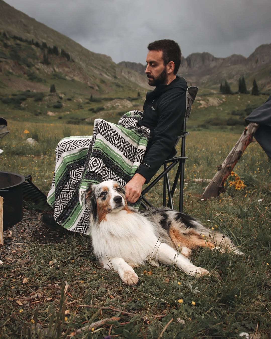 man in nature sitting with dog