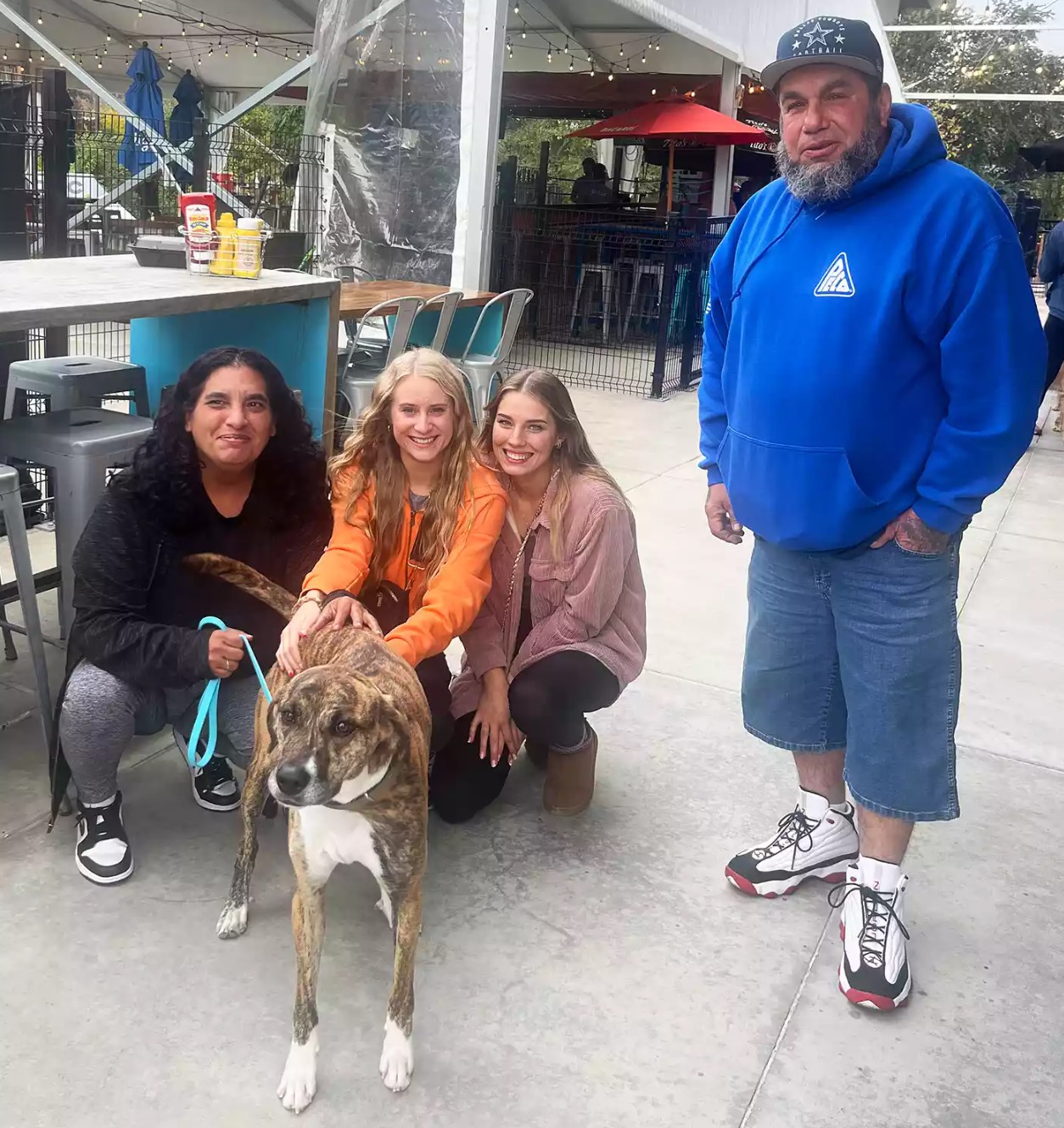 smiling family with dog on the street