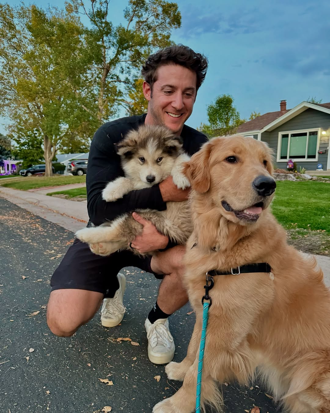 smiling man posing with two dogs