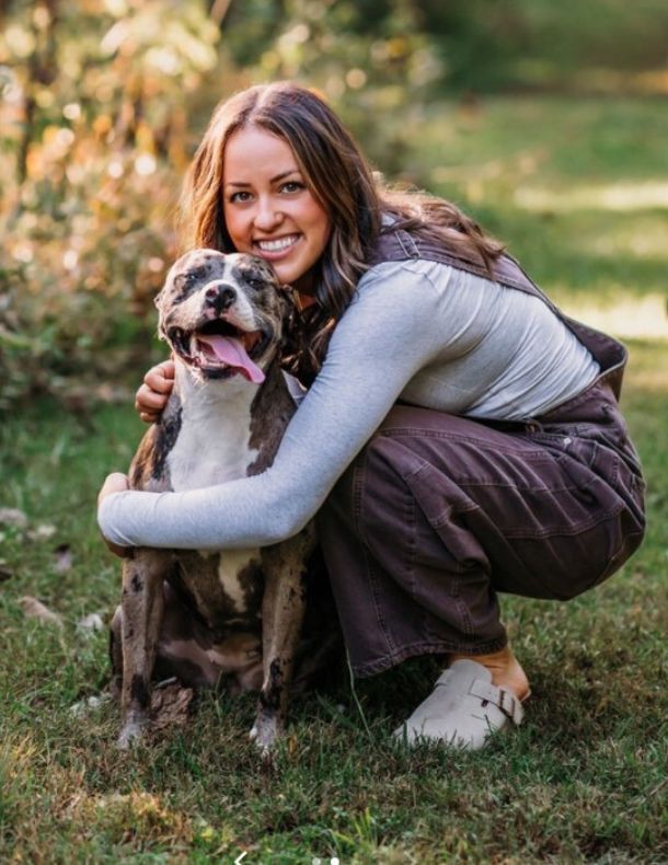 woman hugging dog in a park