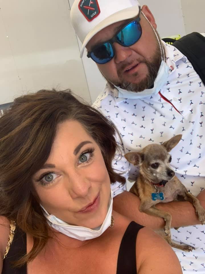 a man and a woman take a picture with a dog