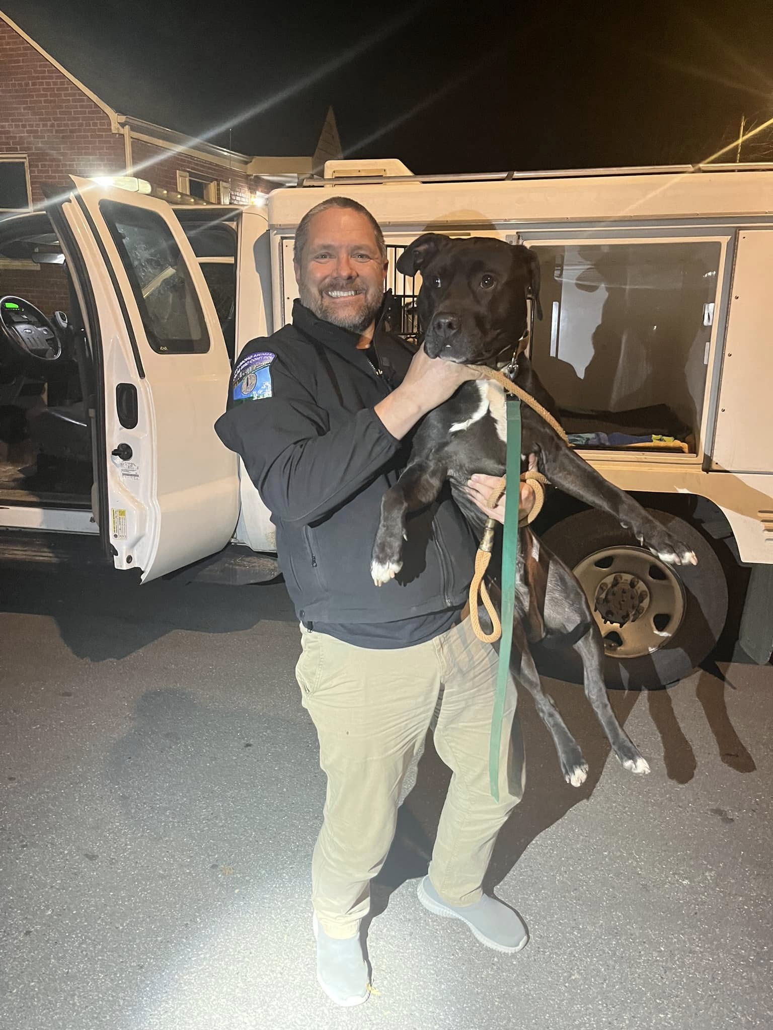 man holding a big black dog