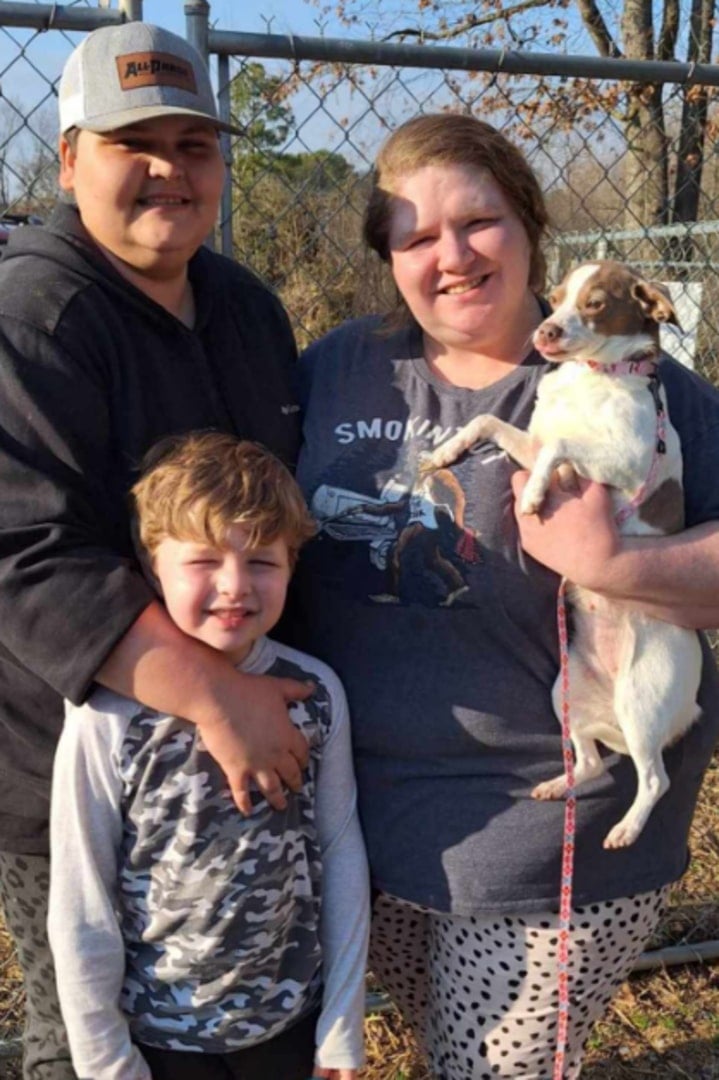 family with dog posing for a picture