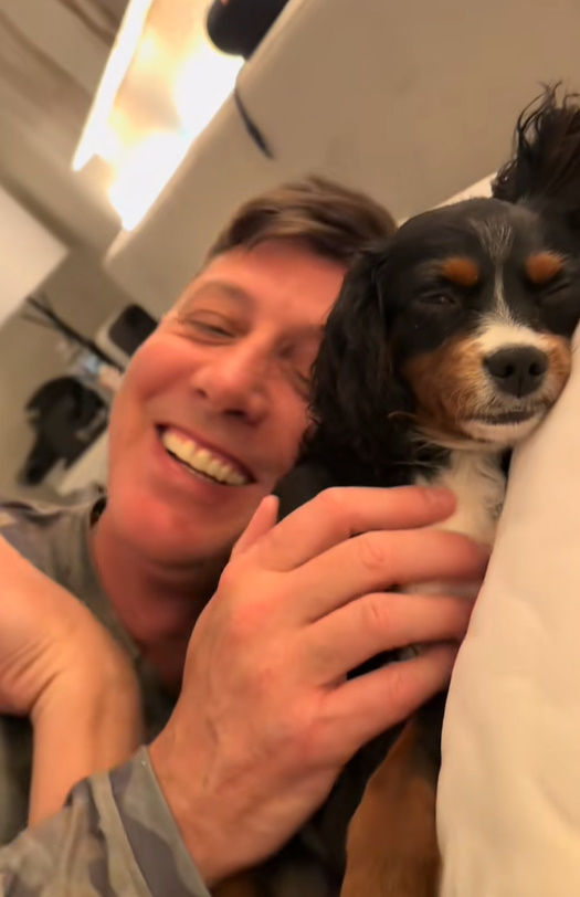 owner and dog laying in bed