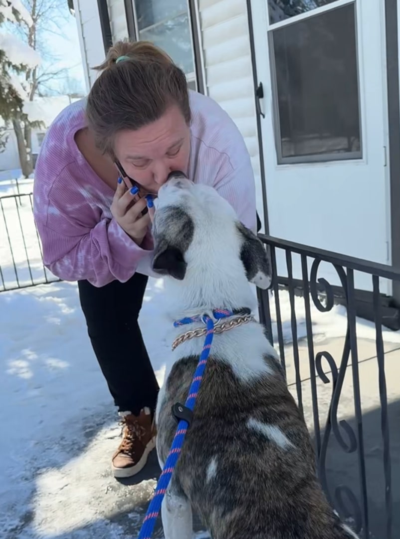 woman kissing a dog